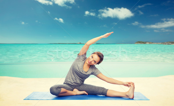 happy woman making yoga and stretching on beach  Stock photo © dolgachov