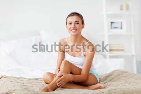 woman with feather touching bare legs on bed Stock photo © dolgachov