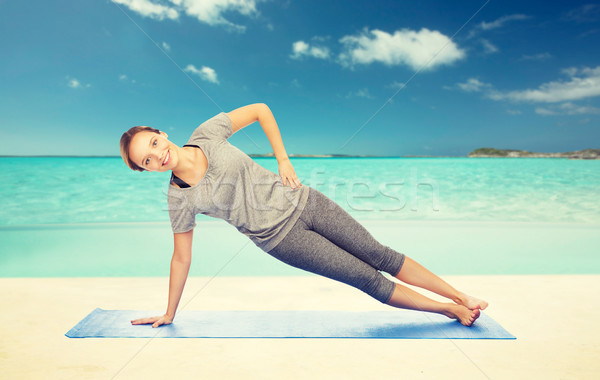 Stock photo: woman making yoga in side plank pose on mat