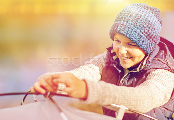 happy boy setting up tent outdoors Stock photo © dolgachov