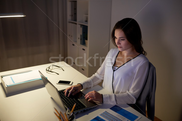 businesswoman typing on laptop at night office Stock photo © dolgachov