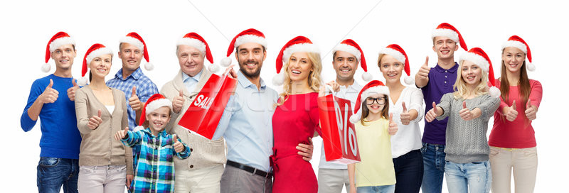 Stock photo: people in santa hats with sale sign at christmas