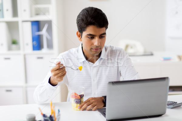 businessman with laptop eating fruits at office Stock photo © dolgachov