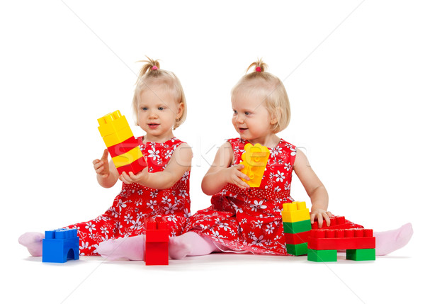 two twin girls in red dresses playing with blocks Stock photo © dolgachov