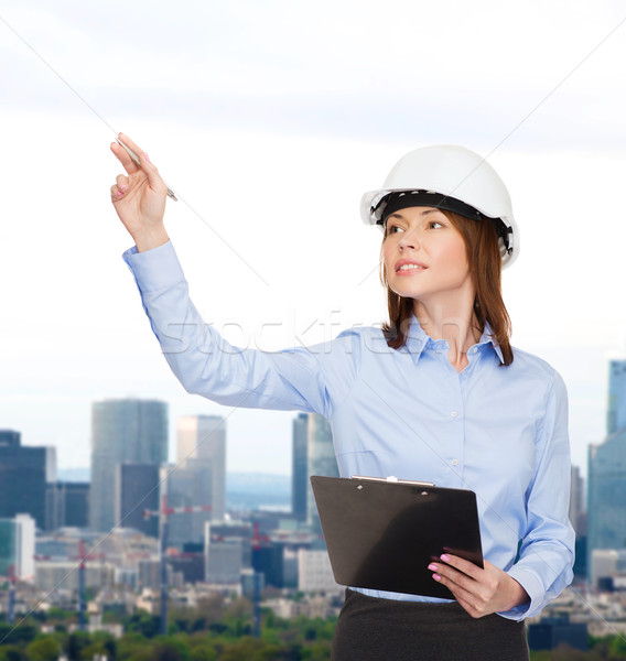 Sorridente empresária capacete clipboard edifício em desenvolvimento Foto stock © dolgachov