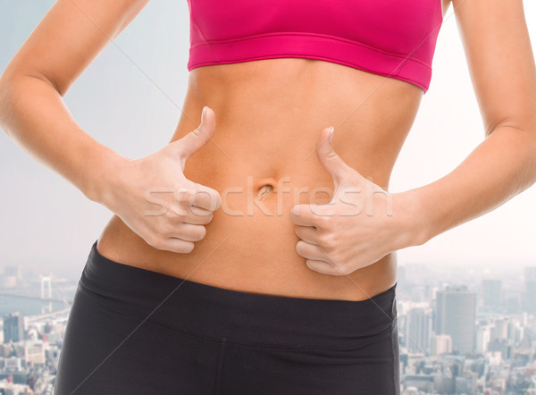 close up of female abs and hands showing thumbs up Stock photo © dolgachov