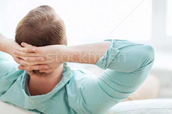 man lying or sitting on sofa at home from back Stock photo © dolgachov