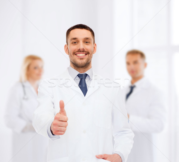 smiling male doctor showing thumbs up Stock photo © dolgachov