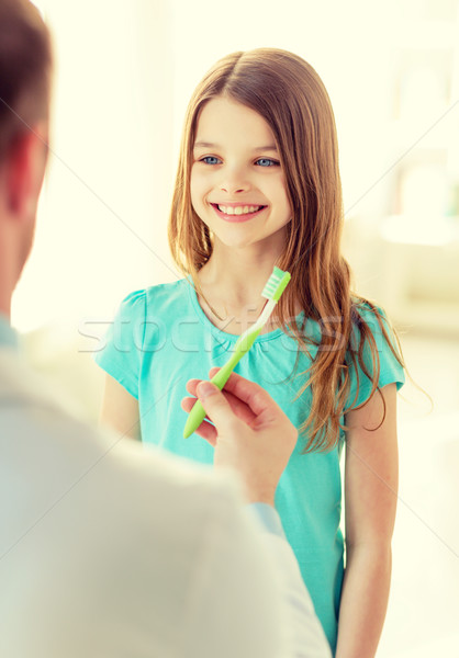 Doctor de sexo masculino cepillo de dientes sonriendo nina salud nino Foto stock © dolgachov