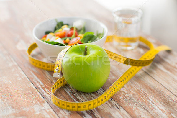 close up of green apple and measuring tape Stock photo © dolgachov