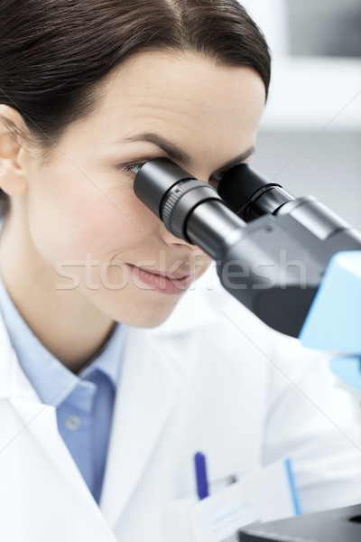 close up of scientist looking to microscope in lab Stock photo © dolgachov