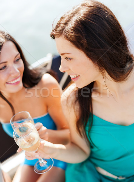 girls with champagne glasses on boat Stock photo © dolgachov