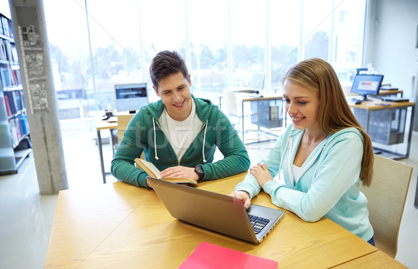 Stock photo: happy students with laptop and books at library