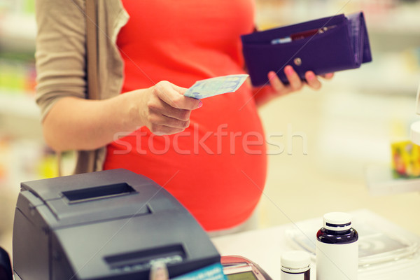 pregnant woman with money at cashbox in drugstore Stock photo © dolgachov