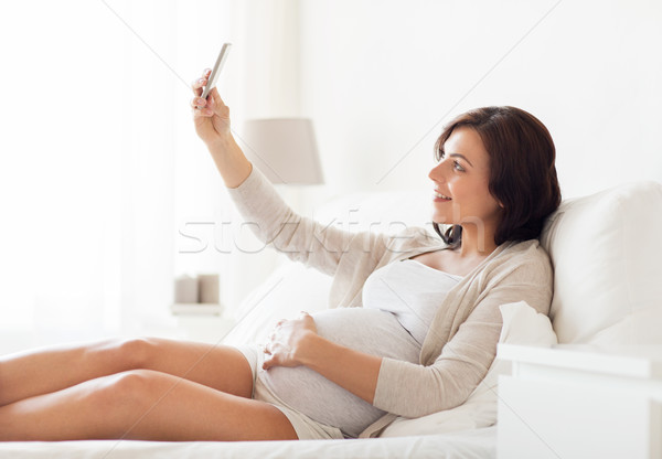 Femeie gravida smartphone acasă sarcină maternitate Imagine de stoc © dolgachov