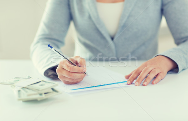 close up of hands with money filling tax form Stock photo © dolgachov