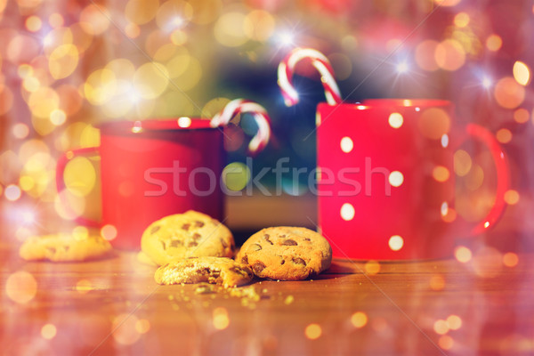 christmas candy canes and cups on wooden table Stock photo © dolgachov