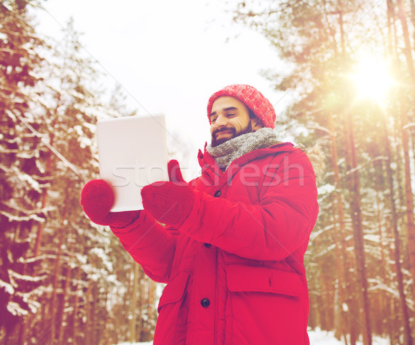 happy man with tablet pc in winter forest Stock photo © dolgachov