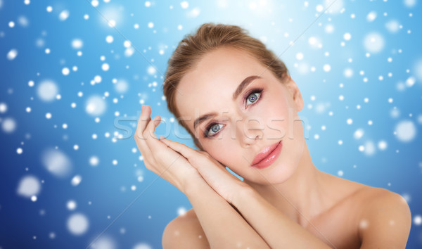 beautiful young woman face and hands over snow Stock photo © dolgachov