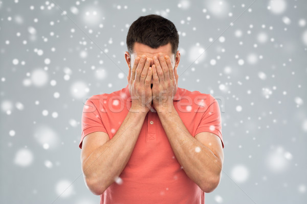 man covering his face with hands over snow Stock photo © dolgachov