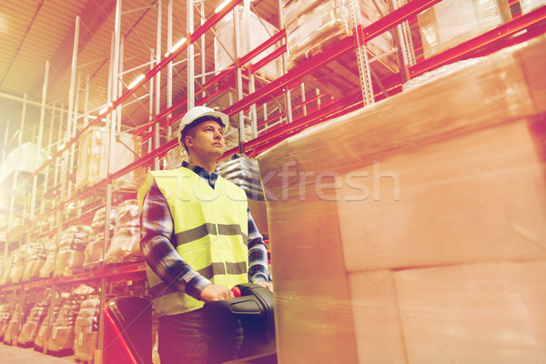 man on forklift loading cargo at warehouse Stock photo © dolgachov