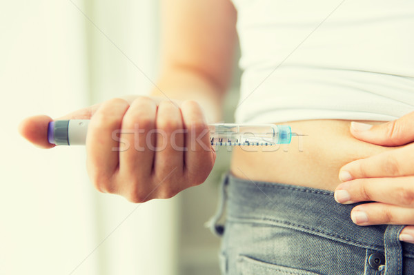 close up of hands making injection by insulin pen Stock photo © dolgachov