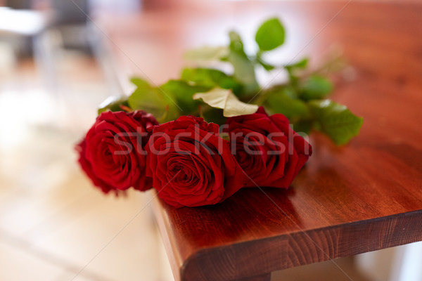 red roses on bench at funeral in church Stock photo © dolgachov