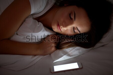 Сток-фото: женщину · смартфон · спальный · кровать · ночь · технологий