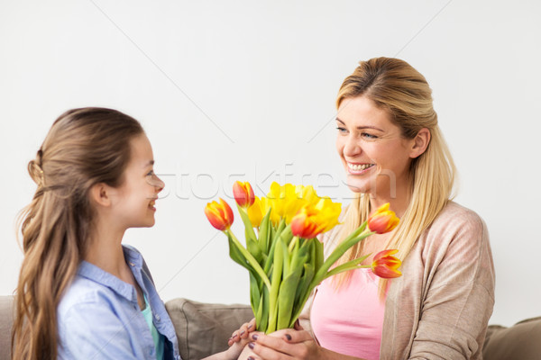 Stock photo: happy girl giving flowers to mother at home