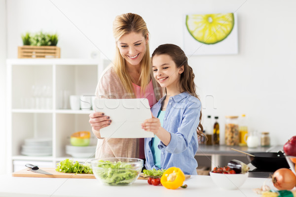 Stock photo: family cooking dinner using tablet pc at kitchen