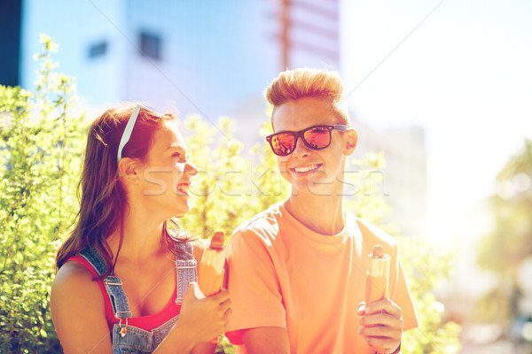 happy teenage couple eating hot dogs in city Stock photo © dolgachov