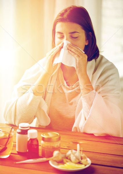 sick woman with medicine blowing nose to wipe Stock photo © dolgachov