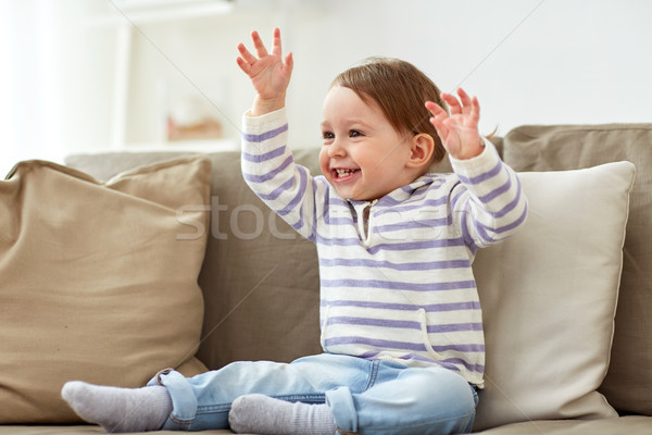 happy smiling baby girl sitting on sofa at home Stock photo © dolgachov