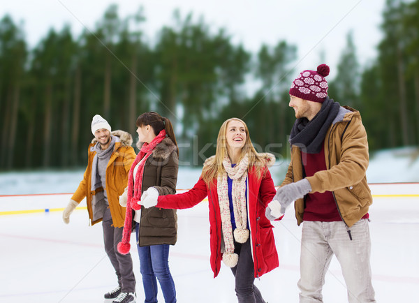 friends holding hands on outdoor skating rink Stock photo © dolgachov