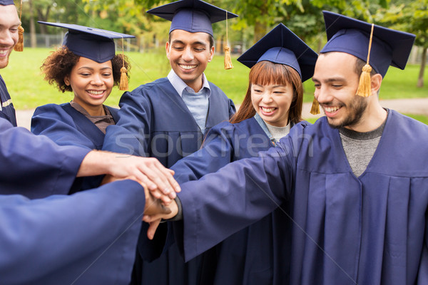 happy students or bachelors in mortar boards Stock photo © dolgachov