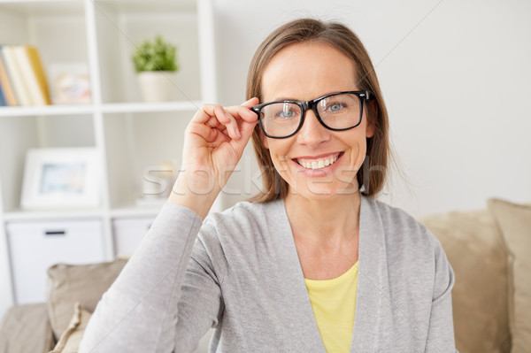 happy smiling woman in eyeglasses at home Stock photo © dolgachov