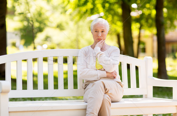 sad senior woman sitting on bench at summer park Stock photo © dolgachov