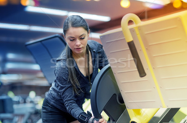 young woman adjusting leg press machine in gym Stock photo © dolgachov