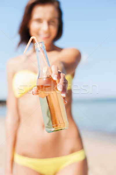 girl with bottle of drink on the beach Stock photo © dolgachov