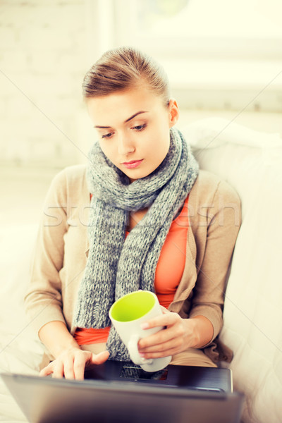 diseased woman in scarf using laptop at home Stock photo © dolgachov