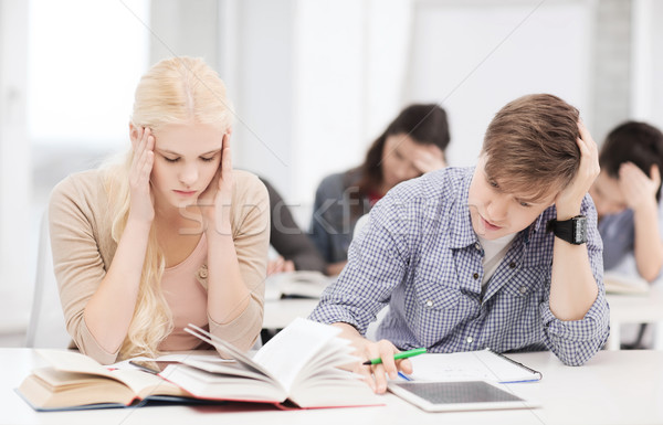 tired students with tablet pc, notebooks and books Stock photo © dolgachov