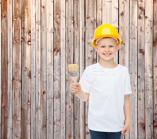 smiling little boy in helmet with paint brush Stock photo © dolgachov