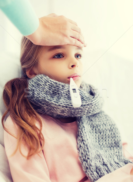 ill girl child with thermometer and caring mother Stock photo © dolgachov