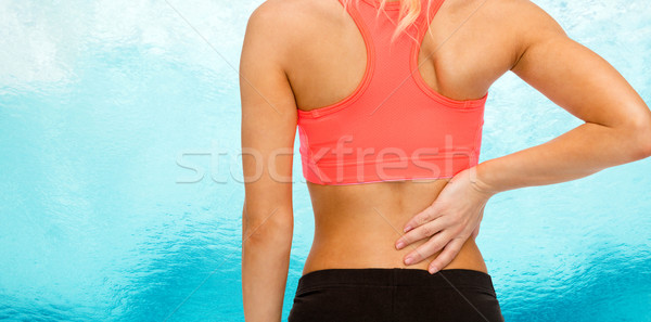 close up of sporty woman touching her back Stock photo © dolgachov