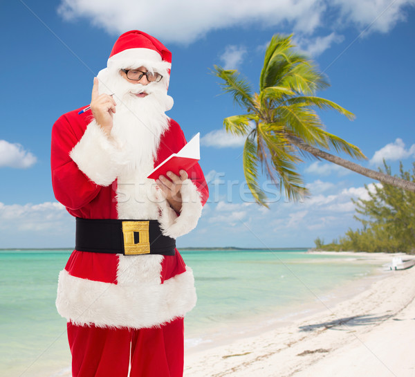 man in costume of santa claus with notepad Stock photo © dolgachov