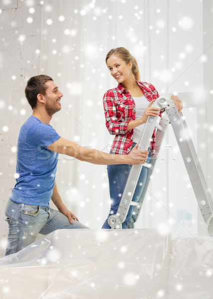 smiling couple with ladder at home Stock photo © dolgachov