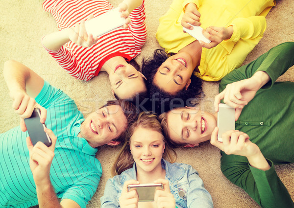 group of smiling people lying down on floor Stock photo © dolgachov