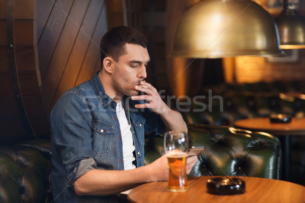 Człowiek pitnej piwa palenia papierosów bar Zdjęcia stock © dolgachov