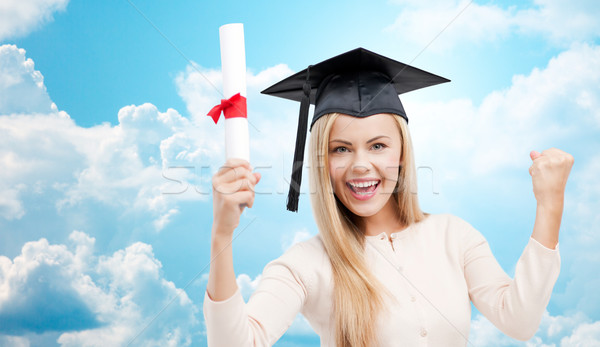 student in trencher cap with diploma over blue sky Stock photo © dolgachov