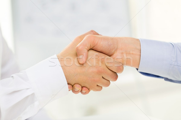 Stock photo: close up of hands making handshake in office